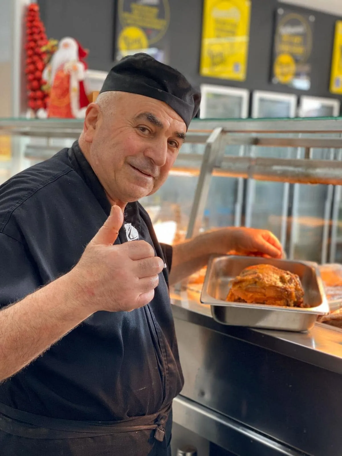 Tony, owner of King of the Roast, giving a thumbs up behind the counter